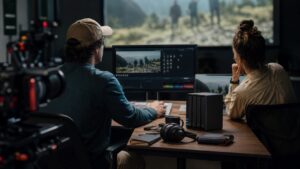 Video editing team reviewing footage in a post-production suite with media storage hardware